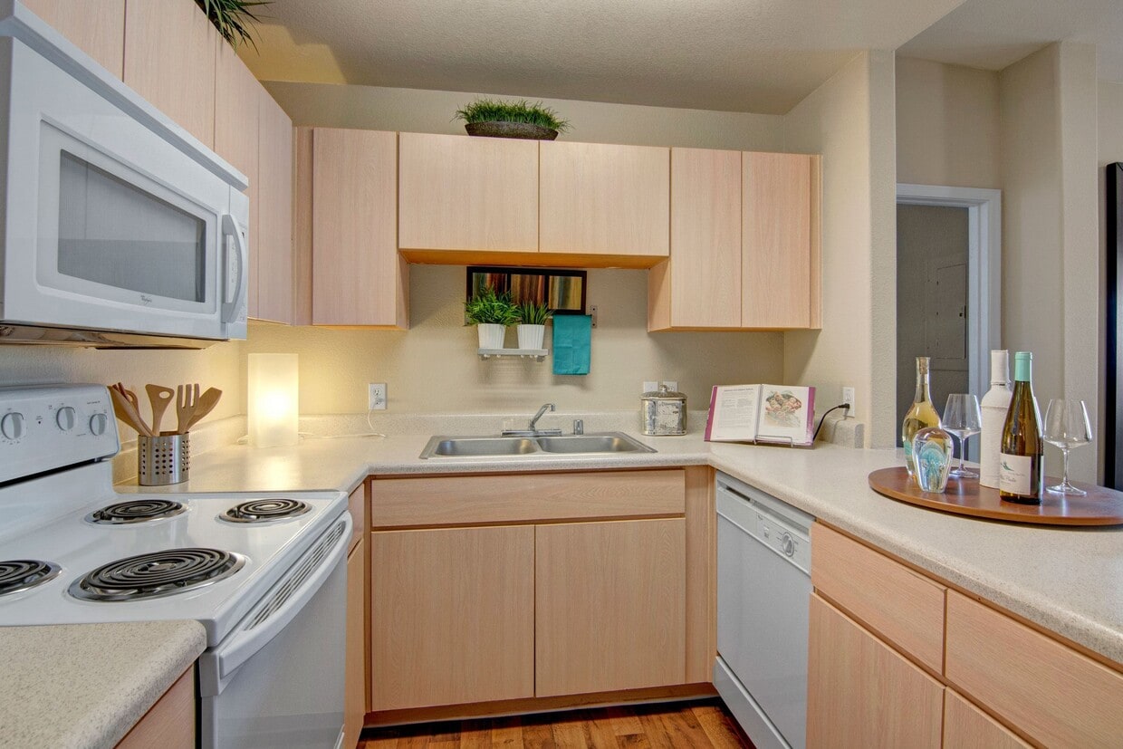 A kitchen with light cabinets and white appliances - Pala Mesa