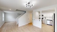 This two-story home in New Castle, Delaware offers a clean, modern aesthetic across two well-appointed levels. The main floor features an open-concept living area with light hardwood flooring, bright white walls, and natural light streaming through windows that overlook the surrounding greenery. A wall-mounted mini-split system ensures year-round comfort. The kitchen is thoughtfully designed with white shaker cabinets, a subway tile backsplash, stainless steel appliances including a range, microwave, dishwasher, and refrigerator, and a light countertop breakfast bar that connects to the living space. The second floor is dedicated to the two bedrooms, both featuring plush carpeting, wall-mounted mini-split units, and generous windows. The spacious primary bedroom offers ample room and includes a double-door closet. A second well-sized bedroom provides additional flexibility. Two full bathrooms serve the home, each finished with dark marble-style tile flooring, white fixtures, and matte black hardware accents, lending a contemporary contrast to the otherwise light palette. Two closets and a hallway complete the upper level. Throughout, the home maintains a cohesive, move-in-ready feel with crisp finishes and a neutral color palette.