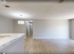Located at 600 Starkey Rd in Largo, FL, this single-floor residence offers 1,180 square feet of thoughtfully arranged living space across 3 bedrooms and 1 bathroom. The open-concept kitchen and living room serve as the heart of the home, featuring light hardwood-style flooring, neutral gray walls, and a textured ceiling. The kitchen is equipped with white shaker cabinetry, marble-style countertops, a subway tile backsplash, black appliances including a refrigerator, electric range, microwave, and dishwasher, plus a peninsula with additional counter space. The living room opens directly onto a private balcony through sliding glass doors framed by lush greenery, filling the space with natural light. The primary bedroom spans 250 square feet and includes plush carpeting, direct access to the bathroom, and a walk-in closet with built-in shelving. The additional bedrooms are carpeted and feature windows with outdoor views. The full bathroom offers a tub/shower combo, marble-style vanity countertop, white cabinetry, and stylish lighting. A dedicated laundry room houses a full-size washer and dryer with overhead shelving. Three closets throughout the unit provide ample storage.