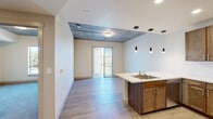 Located at 1320 Decatur St in Denver's vibrant 80204 neighborhood, this single-floor unit blends contemporary design with industrial character. The open-concept living and kitchen area is anchored by a peninsula with a light quartz countertop and an undermount sink, illuminated by sleek pendant lighting. The kitchen is fully equipped with stainless steel appliances, rich warm-toned cabinetry, and a classic subway tile backsplash, creating a functional yet stylish space. Exposed concrete ceilings throughout lend an urban, loft-inspired aesthetic that contrasts beautifully with the crisp white walls and light wood-style flooring. A sliding glass door opens to a private balcony, offering open views of the surrounding greenspace and Denver skyline under Colorado's expansive blue skies. The bedrooms feature plush carpeting, generous closet space, and exposed concrete ceiling details, with windows that draw in ample natural light and outdoor views. The bathrooms are finished with wood-toned vanities, quartz countertops, large mirrors, and a tiled tub-shower combination. This thoughtfully designed unit offers a compelling mix of modern finishes and industrial charm in an accessible Denver location.