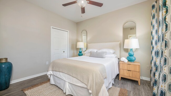 Immerse yourself in the plush serenity of our roomy guest bedroom, where wood-style flooring and a whimsical ceiling fan is everything you desire. Indulge in the comforts of this delightful retreat. - Banyan Bay