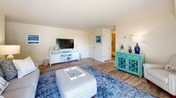Located in Middle River, MD, this thoughtfully designed 2-bedroom, 1-bathroom residence offers a cohesive coastal aesthetic throughout its single-floor layout. The living room serves as an inviting centerpiece, featuring warm hardwood-style flooring, neutral walls, and a large sliding glass door that opens to a private balcony, flooding the space with natural light and offering pleasant outdoor views. The kitchen is equipped with rich dark cabinetry, granite-style countertops, stainless steel appliances including a gas range, built-in microwave, dishwasher, and refrigerator, all complemented by light hardwood-style flooring. The spacious primary bedroom provides a comfortable retreat with ample closet space, large windows, and hardwood-style flooring. The second bedroom carries the same coastal charm, with bright windows and stylish finishes. The full bathroom features a dark wood vanity with a white countertop, tile flooring, and a shower-tub combination. A connecting hallway ties the rooms together seamlessly. Throughout the home, a consistent blue-and-white coastal palette creates a relaxed, welcoming ambiance ideal for comfortable everyday living.