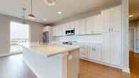 Located at 4455 Winder Dr in Dublin, OH, this well-appointed 2-bedroom, 2-bathroom single-floor residence offers a thoughtfully designed layout with modern finishes throughout. The open-concept kitchen is a standout feature, showcasing crisp white shaker cabinetry, a white tile backsplash, stainless steel appliances including a refrigerator, range, and over-the-range microwave, and a generously sized center island with a quartz-style countertop and undermount sink — ideal for both meal preparation and casual dining. The kitchen flows seamlessly into the living area, which is bathed in natural light through expansive floor-to-ceiling windows offering broad views of the surrounding Dublin cityscape. Warm hardwood-style flooring extends throughout the main living areas, complemented by recessed lighting and a clean, neutral color palette. Both bedrooms are carpeted and well-proportioned, each featuring windows that invite in natural light. The primary bedroom is spacious and connects to a private bathroom with a glass-enclosed walk-in shower, white vanity cabinetry, and brushed nickel fixtures. The second full bathroom is equally well-finished. A dedicated laundry area and utility closet with a water heater and HVAC system round out this efficiently planned home.