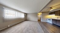Located at 2704 Westmar Ct in Toledo, Ohio, this single-floor, 2-bedroom, 1-bathroom residence offers a functional and comfortable layout. The open living area features neutral-toned walls, plush carpeting, and a large window dressed with vertical blinds that allows natural light to fill the room. A wall-mounted air conditioning unit and baseboard heating ensure year-round comfort. The kitchen flows seamlessly from the living space and is outfitted with dark upper cabinetry, gray lower cabinets, a double-basin sink, a white electric range, and a full-size refrigerator, all set atop durable wood-look vinyl flooring. The primary bedroom is generously proportioned, featuring soft carpet, a large window with blinds, a baseboard heater, and a double-door closet for ample storage. The second bedroom offers a similar comfortable feel with carpet, a window, and baseboard heating. With four closets throughout, storage is plentiful. The bathroom features a clean, white tub and shower surround. Throughout the home, a consistent warm gray color palette and practical finishes create a cohesive, move-in-ready living environment.