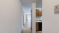 Located at 8183 N 107th St in Milwaukee, Wisconsin, this single-floor, 2-bedroom, 3-bathroom home offers a practical and comfortable layout with consistent hardwood-style flooring throughout. The living room is a bright, open area anchored by a sliding glass door that leads to the outdoors, filling the space with natural light and providing views of the surrounding greenery. A chandelier-lit dining or secondary living area connects seamlessly to the rest of the home via a central hallway lined with dark-stained wood doors that add warmth and contrast to the neutral walls. The galley-style kitchen is well-equipped with abundant warm wood cabinetry, ample counter space, black appliances including a range and refrigerator, and a double sink — making it both functional and efficient. The primary bedroom is generously sized, featuring hardwood-style flooring, a natural light source from a side window, and direct access to a walk-in closet. The bathrooms are clean and practical, with one featuring a wide vanity with wood cabinetry and a large mirror, and another offering a full tub-shower combination. Two closets throughout the home provide convenient storage solutions, rounding out this well-organized and move-in-ready residence.