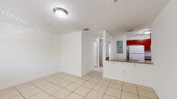 Located at 2437 W 78th St in Hialeah, FL, this 2-bedroom, 1-bathroom apartment offers a practical and well-organized single-floor layout. Light-toned ceramic tile flooring runs consistently throughout the entire unit, creating a clean, cohesive look that is easy to maintain.

The open-concept living area flows directly into the kitchen, which is equipped with rich, warm-toned wood cabinetry, granite-style countertops, a white electric range, a full-size refrigerator, and a stainless steel sink. A peninsula counter separates the kitchen from the living space, providing additional workspace and a casual dining option. A utility panel is conveniently located within the kitchen area.

Both bedrooms feature white walls, tile flooring, and windows with blinds that allow for natural light and outdoor views of surrounding greenery. The primary bedroom offers a generous footprint, while the second bedroom includes a built-in closet with a hanging rod for organized storage. Panel-style doors are featured throughout the unit.

The bathroom is outfitted with a full tub-shower combo featuring tile surround, a wood-cabinet vanity with granite-style countertop, and a mirror. A hallway connects the main living areas to the bedrooms and bathroom, supporting a clear and efficient floor plan throughout this Hialeah apartment.