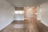 Located at 13439 Peyton Dr in Chino Hills, CA, this single-story home offers a functional and well-appointed layout. The open living and dining area features warm wood-look flooring and a textured ceiling, creating an inviting atmosphere. A ceiling fan adds comfort to the main living space, which flows seamlessly toward the adjacent rooms. Built-in cabinetry along one wall provides convenient storage in the living area.

The galley-style kitchen is efficiently designed with light wood cabinetry, granite-look countertops, a double-basin sink, and a white gas range. A recessed tray ceiling with recessed lighting adds a distinctive architectural detail overhead, while wood-look flooring continues throughout.

The bedrooms are carpeted for comfort and feature neutral tones, textured ceilings, and windows that allow natural light to fill each room. One bedroom includes mirrored sliding closet doors, while another offers a walk-in closet. The full bathroom is clean and bright, featuring a granite-top vanity with white cabinetry, a large mirror, a tub-shower combination, and a window that brings in natural light. Wood-look flooring completes the bathroom's practical design. Overall, the home presents a comfortable and functional living environment in a well-located Chino Hills community.