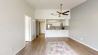 Located on South Harbor Boulevard in Anaheim, this well-appointed one-bedroom, one-bathroom residence offers a thoughtfully designed single-floor layout. The open-concept living and kitchen area serves as the heart of the home, featuring soaring vaulted ceilings, a ceiling fan with a brass-toned fixture, and light wood-look flooring that flows seamlessly throughout. Neutral-toned walls in soft white and gray create a clean, airy atmosphere. A sliding glass door floods the living area with natural light and opens directly onto a private patio, perfect for outdoor relaxation. The kitchen is equipped with white shaker-style cabinetry, granite-look countertops, stainless steel appliances including a refrigerator, range, and microwave, and a breakfast bar that connects to the living space. The generously sized bedroom offers a quiet retreat with ample closet storage accessible through the hallway. The bathroom continues the clean aesthetic with wood-look tile flooring and crisp white walls. A dedicated closet and hallway provide practical storage solutions. This residence combines modern finishes with a comfortable, functional layout in a prime Anaheim location near the Disneyland Resort corridor.