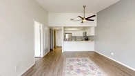 Located on South Harbor Boulevard in Anaheim, this well-appointed one-bedroom, one-bathroom residence offers a thoughtfully designed single-floor layout. The open-concept living and kitchen area serves as the heart of the home, featuring soaring vaulted ceilings, a ceiling fan with a brass-toned fixture, and light wood-look flooring that flows seamlessly throughout. Neutral-toned walls in soft white and gray create a clean, airy atmosphere. A sliding glass door floods the living area with natural light and opens directly onto a private patio, perfect for outdoor relaxation. The kitchen is equipped with white shaker-style cabinetry, granite-look countertops, stainless steel appliances including a refrigerator, range, and microwave, and a breakfast bar that connects to the living space. The generously sized bedroom offers a quiet retreat with ample closet storage accessible through the hallway. The bathroom continues the clean aesthetic with wood-look tile flooring and crisp white walls. A dedicated closet and hallway provide practical storage solutions. This residence combines modern finishes with a comfortable, functional layout in a prime Anaheim location near the Disneyland Resort corridor.