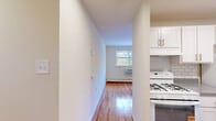 Located at 1600 Garrett Rd in Upper Darby, PA, this two-bedroom, one-bathroom residence offers a practical and well-organized single-floor layout. Warm hardwood flooring runs throughout the living spaces, lending a cohesive, polished look to every room.

The open living and dining area is bright and functional, connecting seamlessly to a kitchen equipped with white cabinetry, a gas range, subway tile backsplash, and ample counter space. A hallway connects the living areas to the private quarters, with multiple closets providing generous storage throughout.

Both bedrooms are well-proportioned, each featuring hardwood floors, natural light from windows with outdoor greenery views, built-in closets with sliding or paneled doors, and wall-unit air conditioning. The primary bedroom offers a comfortable footprint with a large double closet. The second bedroom mirrors this layout with its own closet and window view.

The bathroom is clean and efficiently designed, featuring a white vanity with under-cabinet storage, tiled walls, a mirror, and easy access to the hallway closets. The overall ambiance of the residence is bright and neutral, with white walls and natural light creating an open, airy feel throughout the home.