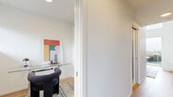 Located in Vancouver's vibrant Mount Pleasant neighbourhood, this two-storey, one-bedroom, one-bathroom residence offers a well-planned layout across two distinct levels. The main floor houses the kitchen, living area, bathroom, and a dedicated office space, while the upper level is devoted to the generously sized bedroom and closet.

The kitchen is a standout feature, finished with sleek grey cabinetry, white quartz countertops, stainless steel appliances including a range and dishwasher, and a striking yellow subway tile backsplash with under-cabinet lighting. Light hardwood flooring runs throughout both levels, adding warmth and continuity to the space.

The upper-level bedroom is notably spacious, offering room for a full furniture arrangement. White walls and warm wood flooring create a calm, minimalist aesthetic, complemented by angled architectural ceilings that add character. A separate closet provides practical storage.

The bathroom is clean and contemporary, featuring large-format floor tiles, a grey floating vanity with a white countertop, and a shower-tub combination. A staircase with natural wood treads connects the two floors, contributing to the open, loft-inspired feel of the home. The overall ambiance is bright, modern, and thoughtfully designed.