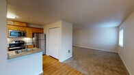 Located at 621 SE 168th Ave in Vancouver, Washington, this single-floor residence offers a practical and comfortable layout with a clean, move-in-ready aesthetic throughout. The kitchen is a standout feature, outfitted with warm-toned wood cabinetry, granite-style countertops, stainless steel appliances including a refrigerator, electric range, and over-the-range microwave, all set atop easy-to-maintain hardwood-style flooring. Generous counter space lines both sides of the kitchen, providing ample room for meal preparation. The living area flows naturally from the kitchen, offering a welcoming open feel with access to a sliding glass door that brings in natural light. Carpeted bedrooms provide a comfortable, quiet retreat, each featuring windows with blinds that allow for adjustable natural light and views of the surrounding greenery. The bathroom is well-appointed with a wood vanity, granite-style countertop, framed mirror, and a full tub-shower combination, all finished with hardwood-style flooring. Closet storage is available within the unit, and neutral wall tones throughout create a bright, cohesive atmosphere. The space presents a functional and inviting living environment in a residential Vancouver neighborhood.