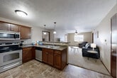 Located at 4620 E 54th St in Sioux Falls, SD, this 2-bedroom, 2-bathroom unit offers a well-designed, single-level layout that maximizes functionality and comfort. The open-concept kitchen and living area serves as the heart of the home, where rich medium-toned wood cabinetry and dark granite countertops complement stainless steel appliances, including a refrigerator, microwave, and dishwasher. A peninsula breakfast bar with pendant lighting and seating for three provides a casual dining option while keeping the kitchen connected to the living space. The living room features plush carpeting, a ceiling fan, and a window that lets in natural light, creating a warm and inviting atmosphere. A door from the living room provides additional access to the exterior. Both bedrooms offer carpeted flooring and windows for natural light, with the primary bedroom featuring direct access to a dedicated bathroom. The two full bathrooms are finished with tile flooring and include tub-shower combinations. Two closets provide ample storage throughout the unit. Neutral tones and consistent finishes carry through the entire space, giving it a cohesive and move-in-ready feel.