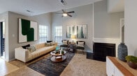 Located at 2105 Ravenglass Pl in Raleigh, NC, this single-floor residence offers a thoughtfully designed layout with comfortable living spaces throughout. The living room serves as the heart of the home, boasting soaring ceilings, a ceiling fan, large windows that invite an abundance of natural light, and a classic fireplace — creating a warm and inviting atmosphere. The kitchen is well-equipped with stainless steel appliances, including a range, over-the-range microwave, and refrigerator, complemented by gray raised-panel cabinetry, light stone countertops, and a white subway tile backsplash. Light hardwood-style flooring adds a clean, modern touch to this functional space. A convenient in-unit laundry closet with a full-size washer and dryer is tucked just off the main living area. The bedrooms are carpeted and feature neutral gray walls; one bedroom showcases unique angled ceiling details and a dedicated closet, while the primary bedroom offers ample space and natural light. The bathroom includes a full soaking tub and shower combination with floor-to-ceiling marble-look tile surround and brushed nickel fixtures, delivering a clean, polished aesthetic throughout.