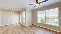 This thoughtfully designed one-bedroom, one-bathroom residence in Bolingbrook, Illinois offers a functional and comfortable single-floor layout. The open-concept living room and kitchen area is bright and welcoming, featuring light wood-tone luxury vinyl plank flooring, neutral beige walls, crown molding, and a ceiling fan with light fixture. Multiple windows dressed with horizontal blinds allow generous natural light and views of the surrounding community. The kitchen is well-equipped with white shaker-style cabinetry, light quartz countertops, a peninsula with an undermount sink, and a full suite of stainless steel appliances including a refrigerator, electric range, and microwave. A dedicated utility area and closet provide practical storage solutions. The bedroom is carpeted for comfort, featuring a ceiling fan and a window with outdoor views. The bathroom includes a white vanity with quartz countertop, overhead cabinetry, a full tub-shower combination with white tile surround, and light hardwood-style flooring. Clean white trim and consistent neutral tones throughout give the space a cohesive, move-in-ready aesthetic.