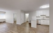 Located at 10001 Bellamy Hill Rd NW, this 2-bedroom, 2-bathroom unit offers a clean, modern aesthetic throughout its single-level layout. Light wood-tone laminate flooring flows seamlessly across the open-concept living and kitchen area, which is bright and spacious. The kitchen is well-equipped with crisp white shaker-style cabinetry, speckled stone countertops, a subway tile backsplash, a stainless steel dishwasher, and a stainless steel sink — offering both style and functionality. The open living area features neutral grey-white walls, flush-mount ceiling lighting, and windows fitted with roller shades that allow natural light while maintaining privacy. Baseboard heating runs beneath the windows throughout the unit. The generously sized primary bedroom provides a comfortable retreat, also featuring a window with a roller shade and the same warm laminate flooring. The second bedroom is equally well-finished and similarly bright. Both bathrooms are outfitted with white subway tile tub-shower surrounds, stone-topped vanities, and wood-tone flooring. A dedicated laundry area houses a stacked front-load washer and dryer unit alongside built-in shelving, adding practical convenience to this thoughtfully designed home.