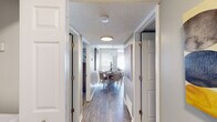 Located at 3400 S Lowell Blvd in Denver, Colorado, this single-floor residence offers a thoughtfully designed layout with a cohesive, contemporary aesthetic. Wood-style flooring runs through the main living areas, complemented by neutral gray tones and clean white trim throughout.

A central hallway connects the key spaces, leading to a dedicated dining area illuminated by a pendant light fixture and fitted with a textured ceiling. The open-concept living room features multiple windows with arched detailing that allow generous natural light to fill the space, creating a bright and welcoming atmosphere. Vertical blinds provide access to an outdoor area.

The kitchen is equipped with white cabinetry, gray countertops, a double stainless steel sink with a brushed gold faucet, and a window above that adds additional natural light. The dining space comfortably accommodates a full table and chairs, ideal for everyday meals or entertaining.

The bedrooms are carpeted for comfort, each offering closet storage and windows with outdoor views. The primary bedroom is generously proportioned, providing ample room for large furniture. The bathroom includes a tub-shower combination, a single vanity with gray countertop, a large mirror, and wood-style flooring.

Overall, the space presents a clean, move-in-ready environment with consistent modern finishes and a practical, well-organized floor plan.