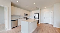 Located at 2020 W Morehead St in Charlotte, NC, this single-floor residence offers a thoughtfully designed layout with modern finishes throughout. The kitchen serves as a central highlight, featuring white flat-front cabinetry, a classic subway tile backsplash, light quartz countertops, a center island, and a full suite of stainless steel appliances including a refrigerator with ice maker, electric range, built-in microwave, and dishwasher. Light wood-tone flooring runs throughout the main living and kitchen areas, lending warmth to the bright, open atmosphere. The living area is generously proportioned with soaring ceilings and a large bank of windows that fill the space with natural light and offer views of the surrounding Charlotte cityscape. The bedrooms are carpeted for comfort, each featuring windows with blinds that invite natural light while maintaining privacy. The primary bathroom includes a walk-in closet, a sleek vanity with undermount sink, wood-tone cabinetry, and a separate glass-enclosed shower. A secondary bathroom offers a tiled tub-shower combination and a matching vanity. Throughout, the design maintains a clean, contemporary aesthetic with a neutral color palette that creates a bright and welcoming environment.