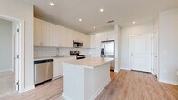 Located at 2020 W Morehead St in Charlotte, NC, this single-floor residence offers a thoughtfully designed layout with modern finishes throughout. The kitchen serves as a central highlight, featuring white flat-front cabinetry, a classic subway tile backsplash, light quartz countertops, a center island, and a full suite of stainless steel appliances including a refrigerator with ice maker, electric range, built-in microwave, and dishwasher. Light wood-tone flooring runs throughout the main living and kitchen areas, lending warmth to the bright, open atmosphere. The living area is generously proportioned with soaring ceilings and a large bank of windows that fill the space with natural light and offer views of the surrounding Charlotte cityscape. The bedrooms are carpeted for comfort, each featuring windows with blinds that invite natural light while maintaining privacy. The primary bathroom includes a walk-in closet, a sleek vanity with undermount sink, wood-tone cabinetry, and a separate glass-enclosed shower. A secondary bathroom offers a tiled tub-shower combination and a matching vanity. Throughout, the design maintains a clean, contemporary aesthetic with a neutral color palette that creates a bright and welcoming environment.