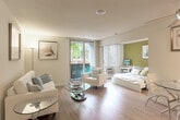 Located at Del Medio Ave in Mountain View, CA, this one-bedroom, one-bathroom residence offers a thoughtfully designed single-floor layout that maximizes every inch of its compact footprint. Warm hardwood-style flooring flows throughout, lending a cohesive and inviting character to the entire space.

A welcoming hallway leads into the bright living room, which features clean white walls, recessed lighting, and large sliding glass doors that open onto a private balcony, filling the space with natural light and outdoor views of the surrounding greenery. The open-plan living and dining area transitions seamlessly into the kitchen, which is outfitted with rich dark wood cabinetry, white countertops, a stainless steel refrigerator, and modern fixtures — a striking contrast that adds visual depth.

The bedroom is accented by a vibrant green feature wall and benefits from direct access to the balcony, creating an airy, serene retreat. The bathroom is well-appointed with dark wood vanity cabinetry, a white countertop, and a combined tub and shower. A full-length mirrored closet door enhances the sense of space. Four closets throughout the residence provide generous storage. A utility room and hallway round out the functional layout of this well-organized Mountain View home.
