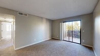 Located at 450 W Cool Dr in Oro Valley, Arizona, this two-bedroom, two-bathroom residence offers a well-organized single-floor layout designed for comfortable everyday living. The carpeted living room is a bright, open space featuring neutral-toned walls, a textured ceiling, and a sliding glass door that opens onto a private balcony with views of surrounding greenery. The kitchen is efficiently laid out with white cabinetry, granite-style countertops, wood-look tile flooring, and black appliances including a refrigerator, range, and microwave. Both bedrooms are carpeted and bathed in natural light from window blinds; the primary bedroom includes direct access to an en-suite bathroom and a walk-in closet with built-in shelving. The bathrooms are finished with granite-style countertops, white vanity cabinetry, large mirrors, wood-look tile flooring, and a shower-tub combination. A connecting hallway links all rooms efficiently. Throughout, the residence maintains a clean, neutral aesthetic with consistent finishes, making it a functional and well-appointed home in a convenient Oro Valley location.