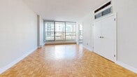 Located at 50 Rosehill Ave in Toronto's vibrant Midtown neighbourhood, this single-floor unit offers a well-organized and efficiently designed layout comprising a generous living room and a full bathroom. The living area is a standout feature, showcasing classic parquet wood flooring in a warm honey tone that extends throughout the space, adding character and a timeless aesthetic. Large floor-to-ceiling windows along one wall flood the room with abundant natural light while framing views of the surrounding urban streetscape, creating an open and airy atmosphere. White walls and clean lines throughout contribute to a bright, neutral palette that complements a variety of interior styles. A wall-mounted climate control unit ensures year-round comfort. The bathroom is finished with crisp white subway tile surrounding a full soaking tub and shower combination, complete with chrome fixtures and an accessibility-friendly grab bar — reflecting both practicality and clean design. The unit also includes a closet and entry area, making efficient use of the available footprint. The overall ambiance is clean, bright, and functional, well-suited for those seeking a manageable, low-maintenance space in one of Toronto's most accessible and walkable neighbourhoods.