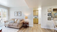 Located at 455 E Center St in Anaheim, CA, this well-appointed one-bedroom, one-bathroom unit offers a comfortable and efficiently designed single-floor layout. Light wood-style flooring flows throughout, creating a cohesive, airy feel across all rooms.

The living room is bright and inviting, anchored by a sliding glass door that fills the space with natural light and opens to a private patio with views of colorful outdoor landscaping. A dedicated dining nook adjacent to the living area provides an intimate setting for meals.

The kitchen features warm, golden-toned cabinetry, dark granite-style countertops, a stainless steel refrigerator, and ample upper and lower cabinet storage, all lit by a window for natural light. It connects seamlessly to the main living area.

The bedroom is generously sized, offering room for a full furniture arrangement, with multiple windows that bring in natural light and a sliding door providing direct outdoor access. A dedicated walk-in closet with built-in shelving and hanging rods offers well-organized storage.

The bathroom includes a tub and shower combination, a large vanity mirror, and matching golden cabinetry consistent with the kitchen's design, all finished with the same warm wood-style flooring found throughout the unit.