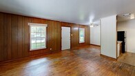 Located at 201 Audubon Dr in Danville, Virginia, this single-floor, 2-bedroom, 1-bathroom home offers a practical and straightforward layout. The living area makes a warm first impression with rich hardwood flooring, wood-paneled walls, and two large multi-pane windows that allow ample natural light and views of the surrounding greenery. A ceiling fan adds functionality to the space.

The galley-style kitchen is efficiently designed, featuring warm wood cabinetry, laminate countertops, a double-basin sink, an electric range, and a full-size refrigerator. Durable vinyl plank flooring runs throughout the kitchen area, complementing the cabinetry tones.

The spacious primary bedroom offers generous square footage, hardwood flooring, a large window for natural light, and multiple doors providing closet and room access. The second bedroom also features hardwood floors, natural light from a window, and a double-door closet set against a wood-paneled accent wall — adding character to the room.

The bathroom is clean and functional, featuring a full bathtub with a shower combo, white surround paneling with built-in shelving niches, and chrome fixtures. Throughout the home, wood trim and baseboards provide consistent detailing that ties the interior together cohesively.