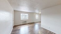 Located at 932 Lincoln St in Portsmouth, Virginia, this single-floor, 2-bedroom, 1-bathroom unit offers a practical and comfortable layout. The living room greets you with durable hardwood-style flooring, a textured ceiling, and dual windows that allow natural light to fill the space. A wall-unit air conditioner and baseboard heating ensure year-round comfort.

The combined dining room and kitchen features light wood-look flooring, white cabinetry with ample upper and lower storage, dark countertops, a double sink, and white appliances including an electric range and refrigerator. A range hood adds functional convenience to the cooking area.

Both bedrooms are carpeted and include ceiling fans with light fixtures and windows with blinds for natural light and privacy. The primary bedroom offers two closets for generous storage. An additional hallway connects the rooms efficiently, with a total of five closets distributed throughout the unit for exceptional organizational flexibility.

The bathroom is appointed with a full tub and shower combination, accented by neutral beige tile surround with chrome fixtures. A utility room rounds out the floor plan, adding further practical storage or laundry space. The unit presents a clean, neutral palette throughout, making it move-in ready.