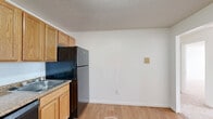 This 630 square foot apartment in Manchester, NH presents a well-designed living space on a single floor. The layout comprises one bedroom, one bathroom, a combined kitchen and living room, a hallway, and a closet. The primary bedroom, measuring 170 square feet, offers ample space for a comfortable retreat.

The kitchen area features modern appliances, including a stainless steel refrigerator and oven, complemented by light wood cabinetry and granite countertops. The living room, adjoining the kitchen, provides a versatile space for relaxation and entertainment. Both areas benefit from warm-toned hardwood flooring, creating a seamless flow between the spaces.

The bathroom, while compact, is efficiently designed with a white tub-shower combination, toilet, and sink. A shower curtain rod allows for privacy, and the inclusion of wooden flooring adds a touch of warmth to the space.

Throughout the apartment, crisp white walls and ceilings create a bright, airy atmosphere. The bedroom and living areas feature plush beige carpeting, enhancing comfort underfoot. Large windows in both the living room and bedroom allow natural light to flood the space, while baseboard heating ensures year-round comfort.

This apartment offers a balance of functionality and style, making it an ideal choice for singles or couples looking for a cozy urban dwelling in Manchester.