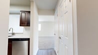 Located at 1000 US Highway 1 in Edison, NJ, this one-bedroom, one-bathroom residence offers a thoughtfully designed single-floor layout with a clean, modern aesthetic. Neutral walls and light-toned baseboards create a bright, cohesive atmosphere throughout.

The kitchen is a standout feature, showcasing rich dark-wood cabinetry with sleek hardware, white countertops, and a full suite of stainless steel appliances including a gas range, built-in microwave, refrigerator, and dishwasher. Light hardwood-style flooring anchors the kitchen and extends into the hallway, providing a warm contrast to the cabinetry.

The open living area flows naturally from the kitchen and is carpeted for comfort, with a sliding glass door that brings in natural light and provides outdoor access. An additional window further brightens the space.

The generously sized bedroom features plush carpeting, natural light from a dedicated window, and dual closets with built-in rods, offering ample storage. The hallway connects the rooms efficiently and includes an additional closet.

The bathroom is finished in a clean, minimalist style with tile flooring, a glass-enclosed walk-in shower, and crisp white walls. Overall, the residence presents a well-maintained, move-in-ready environment with practical amenities throughout.