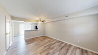 This two-bedroom, two-bathroom two-story home in Ashland, Virginia offers a functional and well-appointed layout spread across two floors. The main level features an open living room with light-toned luxury vinyl plank flooring, a ceiling fan, and a pass-through connection to the kitchen, which is equipped with gray shaker-style cabinetry, striking marble-look quartz countertops, black appliances including a refrigerator, gas range, microwave, and dishwasher, and access to natural light through vertical blinds. A hallway and utility room complete the lower level. Upstairs, the two bedrooms offer plush wall-to-wall carpeting, neutral tones, and natural light from windows fitted with blinds. The primary bedroom includes multiple closet doors, providing ample storage. Both bathrooms feature clean white tile surrounds with tub-shower combinations, maintaining a crisp and functional aesthetic throughout. With five closets distributed across the home and a staircase connecting both levels, the layout makes efficient use of space. The overall design is clean, modern, and move-in ready, with consistent neutral finishes that create a bright and cohesive living environment.