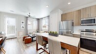 This thoughtfully designed 1-bedroom, 1-bathroom residence offers a cohesive open-concept layout that maximizes every square foot across a single floor. Light wood-style flooring flows continuously throughout, lending warmth and visual continuity to the entire space.

The kitchen is a standout feature, outfitted with light wood cabinetry extending to the ceiling, white quartz countertops, and a full suite of stainless steel appliances including a refrigerator, range, microwave, and dishwasher. A central island with seating provides additional prep space and serves as a natural transition into the dining and living areas.

The living room benefits from multiple windows allowing abundant natural light, complemented by a ceiling fan and direct access to an exterior door. The bright, neutral palette creates an airy, comfortable atmosphere.

The bedroom is a well-proportioned retreat featuring a ceiling fan, a large window, and direct access to a walk-in closet with built-in shelving and hanging space. The full bathroom is finished with wood-toned cabinetry, a white quartz vanity, a large mirror, and a shower-tub combination. A hallway connects the private areas of the residence, completing a functional and modern floor plan.