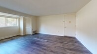 Located at 201 Midlass Dr, Unit 1D in Middle River, MD, this two-bedroom, one-bathroom unit offers a practical and well-appointed single-floor layout. Wood-look flooring flows consistently throughout the living areas and bedrooms, providing a cohesive and easy-to-maintain interior. The spacious living room features neutral walls, a louvered closet door for additional storage, and direct access to the front entry, creating an open and welcoming atmosphere. The kitchen is well-equipped with dark espresso cabinetry, granite-style countertops, and a full suite of stainless steel appliances including a gas range, over-the-range microwave, dishwasher, and refrigerator. A window above the dining area brings in natural light. The primary bedroom is generously sized and features dual closets with paneled doors and natural light from a window. The second bedroom also benefits from a window with outdoor views and wood-look flooring. The bathroom includes a dark-cabinetry vanity with a white countertop, a large mirror, and a full soaking tub with tile surround. A connecting hallway ties all rooms together efficiently, completing this well-organized and move-in ready home.