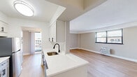 Located at 570 W Dekalb Pike in King of Prussia, PA, this two-bedroom, one-bathroom unit offers a thoughtfully updated interior with clean, modern finishes throughout. The open kitchen-living area serves as the heart of the home, featuring light hardwood-style flooring, white shaker cabinetry with matte black hardware, quartz countertops, a stainless steel sink, and a full suite of stainless steel appliances including a gas range, microwave, and refrigerator. A peninsula counter provides additional prep space and a natural transition to the living area, which receives natural light through large windows with outdoor views. The private balcony extends the living space outdoors, offering an elevated view of the surrounding King of Prussia area. Both bedrooms are carpeted and feature wall-unit climate control and windows that bring in natural light. The primary bedroom includes a built-in closet with sliding doors. The bathroom is finished with large-format marble-look tile surrounding a soaking tub and shower, complemented by a matte black fixture set for a contemporary touch. A dedicated closet provides additional storage. The unit's neutral color palette and updated finishes create a clean, move-in-ready aesthetic throughout.