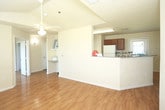 Located at 1102 N Memphis Ave in Lubbock, Texas, this single-story home offers a well-designed layout with consistent warm wood-style flooring throughout. The open living area is bathed in natural light from large windows fitted with blinds, and is topped by a ceiling fan with a light fixture. Vaulted ceiling details add a sense of openness to the main living space, which flows naturally toward the front entry door.

The kitchen is thoughtfully appointed with rich wood cabinetry, granite-style countertops, and white appliances including a refrigerator, electric range, and microwave. A peninsula counter connects the kitchen to the living area, providing additional prep space and a natural gathering point.

The bedrooms are generously sized, each featuring wood-style flooring, ceiling fans, and windows that bring in abundant natural light. At least one bedroom includes a walk-in closet with built-in shelving, offering practical storage solutions.

The bathroom is finished with neutral tile flooring, a glass-enclosed shower, and clean, functional fixtures. Hallways connecting the rooms are well-lit and provide smooth circulation throughout the home. Overall, the space presents a bright, clean, and functional interior suited for comfortable everyday living.