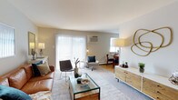 This thoughtfully designed single-floor residence offers a comfortable and cohesive layout across its key living spaces. The living room is the heart of the home, bathed in natural light streaming through large sliding glass doors fitted with vertical blinds that open to an outdoor area. The space features neutral-toned walls, plush carpeting, and room for versatile furniture arrangements, creating an inviting atmosphere for both relaxing and entertaining. A wall-mounted air conditioning unit ensures year-round comfort.

The bedroom is a serene retreat, highlighted by a bold navy accent wall that adds depth and sophistication. Generous closet space, including a walk-in closet, provides ample storage, while soft carpeting and warm lighting contribute to a restful ambiance. A dedicated nook within the bedroom accommodates a home office setup, adding functional versatility.

The kitchen features warm honey-toned wood cabinetry with arched detailing, dark granite-style countertops, and white appliances, delivering a classic and practical cooking space with plentiful storage. The full bathroom is finished in clean, bright white tones with tile flooring, a single-sink vanity, and a shower-tub combination, offering a crisp and functional design. Throughout the residence, consistent finishes and a neutral palette create a harmonious, move-in-ready environment.