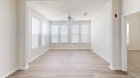 Located at Mountain Falls Ct in Raleigh, NC, this two-story residence offers a well-organized layout across two floors, with the main floor comprising the majority of the living space and an upper level providing additional room. The open-concept main floor integrates a combined kitchen and living area alongside a dedicated living room, connected by a hallway and two staircases.

The kitchen is equipped with light maple cabinetry, dark granite-style countertops, stainless steel appliances including a French door refrigerator, electric range, and microwave, complemented by tile flooring and track lighting overhead. The living room features light hardwood flooring, a ceiling fan, and a generous bank of windows that invite ample natural light. A fireplace anchors one end of the main living area.

The primary bedroom stands out with notably tall vaulted ceilings, carpet flooring, and direct access to a private en-suite bathroom featuring a dual-sink vanity with warm wood cabinetry, tile flooring, and a walk-in closet with built-in wire shelving. Additional bedrooms are carpeted and include ceiling fans. The second full bathroom offers a tub-shower combination with tile surround and a single-sink vanity.