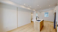 This 670 square foot property in Calgary, AB, showcases a modern and efficient living space across two floors. The interior boasts a clean, minimalist aesthetic with crisp white walls and light wood flooring throughout, creating a bright and airy atmosphere. The kitchen is a highlight, featuring sleek white cabinetry contrasted with wood lower cabinets, stainless steel appliances, and a functional island with a sink. Recessed lighting and large windows provide ample natural light. The bathroom offers a contemporary design with a glass-enclosed shower, white fixtures, and a wooden vanity. The property includes multiple rooms, each with potential for various uses, some with built-in storage solutions. A notable feature is the use of space-saving sliding barn doors. The layout appears open and flowing, maximizing the compact square footage. This property combines style and functionality, ideal for those seeking a modern, low-maintenance living space in an urban setting.