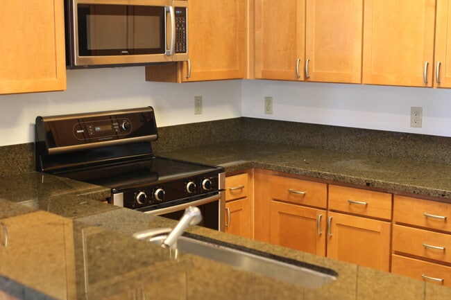 Full-size kitchen with stove, oven, microwave, refrigerator, and granite countertop space - 300 Murchison Dr, #202