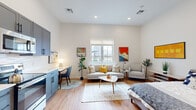 Located at 75 Canal St in Manchester, New Hampshire, this thoughtfully designed studio offers a bright, open-concept layout that efficiently combines living, sleeping, and dining areas into one cohesive space. Warm hardwood-style flooring flows throughout, complemented by tall ceilings and recessed lighting that amplify the sense of openness and airiness.

The living area is well-proportioned, featuring a large window that invites natural light and frames views of the surrounding neighborhood. A dedicated dining nook and a built-in desk area provide functional zones within the open floor plan, while a closet offers convenient storage.

The kitchen is fully equipped with slate-blue shaker-style cabinetry, white countertops, and a complete suite of stainless steel appliances, including a refrigerator, range, microwave, and dishwasher — making it as practical as it is stylish.

The bathroom continues the modern aesthetic with gray shaker-style cabinetry, a white countertop vanity, a large mirror with globe lighting, and matte black fixtures, all set against light hardwood flooring.

Clean white walls and contemporary finishes throughout create a cohesive, modern ambiance, making this studio an efficient and attractive urban living space in the heart of Manchester.