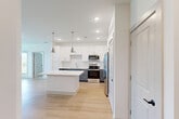 Located at 6735 Standifer Gap Rd in Chattanooga, TN, this well-designed 2-bedroom, 2-bathroom single-story residence offers a thoughtful layout with modern finishes throughout. The open-concept kitchen and living area serves as the heart of the home, showcasing light hardwood flooring, recessed lighting, and a central island with a crisp white countertop. The kitchen is outfitted with two-tone cabinetry — white upper cabinets paired with grey lowers — a classic subway tile backsplash, stainless steel appliances including a refrigerator, range, and microwave, and stylish pendant lighting that adds a contemporary touch. A door with a sidelight window connects the living area to the outdoors, filling the space with natural light. Both bedrooms are comfortably sized, featuring plush carpeting, ceiling fans, and windows framing pleasant outdoor views of the surrounding greenery. The primary bedroom includes a dedicated closet with built-in wire shelving for organized storage. The bathrooms are finished with grey vanity cabinetry, white countertops, wood-look flooring, and a tub-shower combination with marble-style surround tile. A hallway connects all areas efficiently, and two closets provide ample additional storage throughout the home.