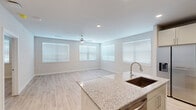 Located at 1610 Campbell Road in Houston's 77055 zip code, this well-appointed single-story, 2-bedroom, 2-bathroom home offers a clean, modern aesthetic throughout. The open-concept living and kitchen area serves as the heart of the home, where light wood-look flooring, recessed lighting, and multiple windows with white blinds create a bright, airy atmosphere. A ceiling fan adds comfort to the spacious living area. The kitchen is outfitted with granite countertops, a central island with a stainless steel sink, gray shaker-style cabinetry, a subway tile backsplash, and a full suite of stainless steel appliances including a refrigerator, range, and over-the-range microwave. Both bedrooms continue the home's consistent design language with light flooring, ceiling fans, and generous natural light from large windows. The primary bedroom is a comfortable size and includes its own en-suite bathroom and a walk-in closet. Both bathrooms feature granite-topped vanities with undermount sinks, gray cabinetry, and wood-look flooring. The home's neutral color palette and modern finishes provide a clean, move-in-ready environment throughout.