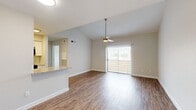 This efficiently designed 1-bedroom, 1-bathroom unit offers a thoughtful layout across a single floor. The open-concept living room and kitchen area serves as the heart of the unit, featuring wood-style flooring that runs throughout the space. Vaulted ceilings and a ceiling fan add architectural interest to the living area, while a sliding glass door floods the room with natural light and provides outdoor access. The galley-style kitchen is well-equipped with stainless steel appliances — including a refrigerator, electric range, microwave, and dishwasher — complemented by white shaker cabinetry, granite-style countertops, and a classic white subway tile backsplash. The bedroom offers a comfortable, private retreat with a dedicated window for natural light and convenient closet access. The bathroom is finished with a white vanity, granite-style countertop, vessel sink, framed mirror, and a tiled shower-tub combination. Neutral tones on the walls, clean white baseboards, and consistent wood-style flooring throughout create a cohesive and move-in-ready aesthetic across the entire unit.