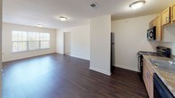 This two-bedroom, two-bathroom unit is thoughtfully laid out across a single floor, offering a functional and comfortable living experience. The open-concept living and dining area features rich, dark hardwood-style flooring that extends throughout the main living spaces, creating a cohesive and clean aesthetic. Natural light filters in through windows, brightening the neutral-toned walls.

The kitchen is efficiently designed with warm maple cabinetry, a granite-look countertop, a double-basin sink, and black appliances including a range, microwave, and dishwasher, as well as a refrigerator. The layout allows for a seamless flow between the kitchen and the main living area.

Both bedrooms are carpeted for comfort and feature ample space. One bedroom includes a walk-in closet, while the other benefits from a window that invites natural light. Each bedroom provides convenient access to the bathrooms. The bathrooms are finished with hardwood-style flooring, light wood vanities, and clean white fixtures, including a full soaking tub with built-in shelving in one bathroom. Overall, the unit presents a clean, functional, and move-in-ready environment suited for everyday living.