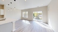 Located at 86 Creek Road in Poughkeepsie, NY, this thoughtfully designed one-bedroom, one-bathroom residence offers a bright and modern living experience across a well-utilized single floor. The open-concept layout seamlessly connects the living room and kitchen, creating a cohesive and functional space ideal for everyday living.

The living area is bathed in natural light streaming through large windows and a sliding glass door that opens to a private balcony, offering pleasant outdoor views of the surrounding greenery. Light-toned hardwood-style flooring runs throughout, complementing the neutral beige walls and recessed lighting that contribute to the home's clean, contemporary aesthetic.

The kitchen is well-appointed with white shaker cabinetry, quartz countertops, stainless steel appliances including a refrigerator, electric range, and microwave, as well as pendant lighting that adds a stylish touch. A spacious peninsula with an integrated sink provides additional prep space and doubles as a breakfast bar.

The generously sized primary bedroom features recessed lighting, a large window with outdoor views, and access to two closets, offering ample storage. The full bathroom is finished with large-format tile flooring, a combined tub and shower, and a vanity with brushed gold hardware. The overall design is clean, modern, and move-in ready.