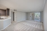 Located at 5636 Amaya Dr in La Mesa, CA, this well-appointed 2-bedroom, 2-bathroom residence offers a thoughtfully designed single-level floor plan. The open-concept living and dining area features neutral-toned carpet, crown molding, a ceiling fan, and a sliding glass door that leads to a private balcony with outdoor views, filling the space with natural light.

The modern kitchen is outfitted with rich dark-wood cabinetry, stainless steel appliances including a refrigerator, range, and microwave, crisp white countertops, wood-look flooring, and a peninsula with an undermount sink — ideal for both cooking and casual dining.

The primary bedroom offers a comfortable footprint with a window overlooking greenery, plush carpet, and generous closet space. The second bedroom is equally well-sized and bright. Both bathrooms maintain a consistent modern aesthetic, featuring dark wood vanities, white countertops, wood-look tile flooring, and full tub/shower combinations. One bathroom includes a glass-enclosed shower with a grab bar.

Hallways are carpeted and lined with mirrored closet doors, maximizing both storage and visual space. A dedicated in-unit laundry area adds everyday convenience. The neutral gray palette and modern finishes throughout lend the space a clean, cohesive look.