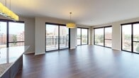 Located in the vibrant Midtown neighborhood of St. Louis, this 2-bedroom unit at 4643 Lindell blends contemporary design with thoughtful functionality across a single floor. The open-concept living and dining area is anchored by warm hardwood flooring and flows seamlessly into a well-appointed kitchen featuring rich dark-walnut cabinetry, granite countertops, a subway tile backsplash, a central island, and a full suite of stainless steel appliances. Large floor-to-ceiling sliding glass doors bathe the living space in natural light and open to a private balcony offering sweeping views of the St. Louis skyline and surrounding neighborhood. A wide hallway with hardwood floors connects the main living area to both bedrooms, each of which is finished with plush carpeting and oversized windows framing elevated city and treetop views. The unit includes two full bathrooms, both featuring granite-topped dark wood vanities and tile flooring. The primary bath offers a tub-shower combination with warm-toned tile surround, while the secondary bath provides a clean, accessible layout. A half bath with matching granite vanity serves as a convenient guest powder room. The overall aesthetic is clean, modern, and cohesive throughout.
