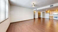 Located at 3401 S Broadway in Englewood, Colorado, this two-bedroom, one-bathroom residence offers a well-organized single-floor layout designed for comfortable everyday living. The open living room greets you with warm wood-look flooring, neutral walls, and a modern flush-mount light fixture, with views leading directly to the bedroom hallway and kitchen area.

The kitchen is efficiently designed with ample light maple cabinetry extending to the ceiling for generous storage, white appliances including a range, microwave, refrigerator, and dishwasher, complemented by white countertops and a stainless steel sink. Recessed lighting adds a bright, functional feel to the space.

Both bedrooms feature plush carpeting and vertical-blind windows that allow natural light to filter in. The spacious primary bedroom offers a comfortable footprint, while the second bedroom provides a clean, versatile space. Two dedicated closets—including a walk-in style with wire shelving—offer practical storage solutions.

The bathroom is well-appointed with a wood-toned vanity, white countertop, a large mirror, and a full tub-shower combination accented with clean white tile surround. Rich wood-look flooring ties the bathroom together, maintaining a consistent aesthetic throughout the home.