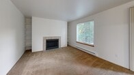 Located in Bothell, WA, this single-floor, 2-bedroom, 3-bathroom home offers a practical and comfortable layout across a well-utilized footprint. The living room serves as the heart of the space, featuring a tile-surround fireplace, built-in shelving on either side, plush carpeting, and a large window that frames views of lush greenery, filling the room with natural light. The adjoining dining area flows naturally from the living space, supporting an open, connected feel.

The kitchen is efficiently designed with light wood cabinetry, ample counter space, a double sink, and white appliances including a range, dishwasher, and refrigerator. The tile flooring adds a clean, durable finish to the cooking area.

Both bedrooms are carpeted and comfortably sized, with the primary bedroom offering generous proportions. A hallway with tile flooring leads through the home, flanked by closets with wood-paneled sliding doors. The three bathrooms include tub/shower combinations with clean white surrounds and tile flooring.

Additional highlights include an in-unit laundry room, a private balcony, and a textured-ceiling hallway that transitions smoothly between living and sleeping areas. Baseboard heating is present throughout. This home offers a cohesive, functional layout well-suited for everyday living.
